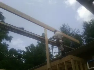 Carpenter setting a ridge beam over a new addition frame — Ice Dam Removal by Roofing Brothers in Canajoharie