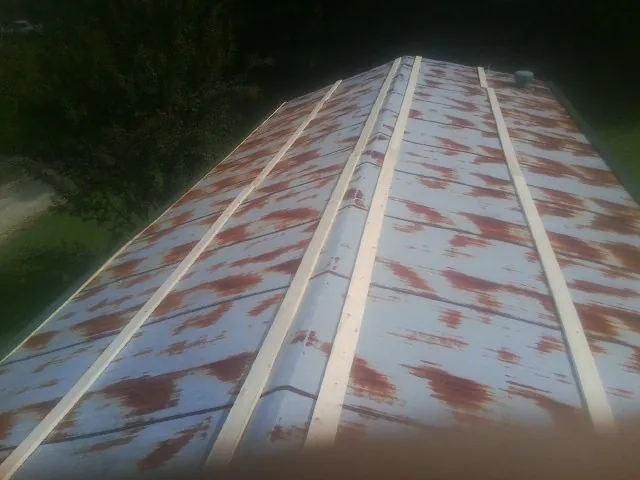 Rusted metal roof panels with new wood purlins before replacement — Storm Damage Roof Repair in Canajoharie by Roofing Brothers