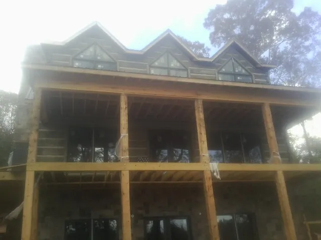 Dormers and porch framing on a large log home under construction — Roof Coating work by our crew in Canajoharie