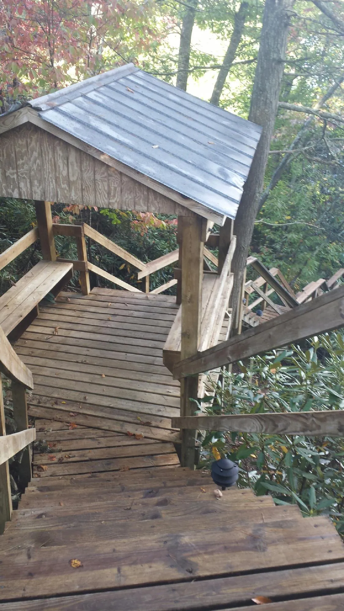 Metal roofed shelter over wooden steps on a wooded walkway — Skylight Repair & Installation work by our crew in Canajoharie