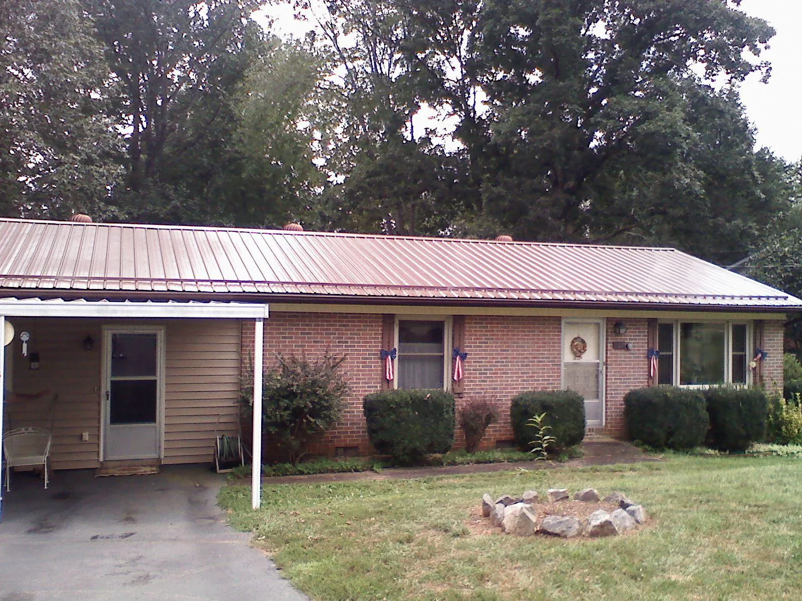 Bronze metal roof and carport on a brick ranch home — Roof Repair work by our crew in Canajoharie